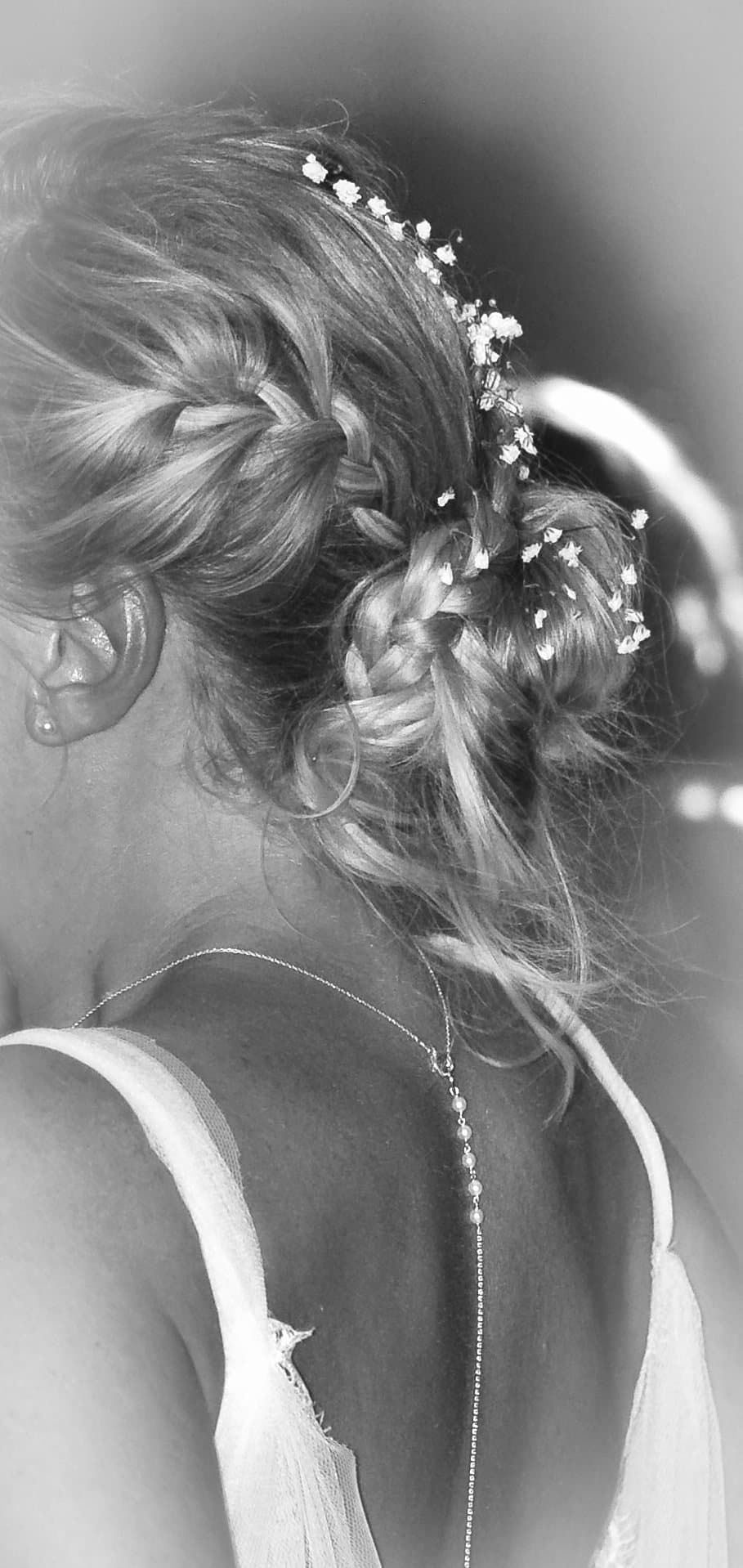 Chignon tressé de la mariée piqué de gypsophile, vu de dos